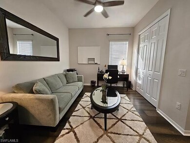 Living room with dark wood-style flooring, an office area, and ceiling fan