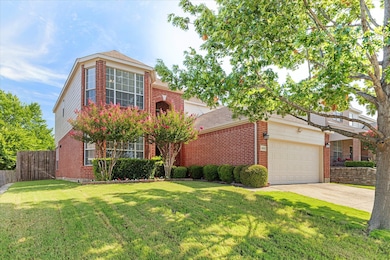 Traditional-style home featuring concrete driveway, a garage, and brick siding