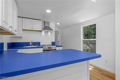 Kitchen with wall chimney range hood, electric ran