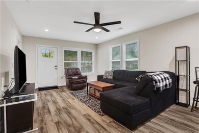 Living room featuring a ceiling fan, visible vents