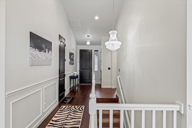 Hall with LVP flooring, a chandelier, recessed lighting, and a wainscoted wall