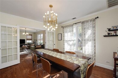 Dining room featuring a chandelier, dark wood-style floors, ornamental molding, and plenty of natural light