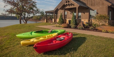 View of home's community with a lawn, a water view, and a porch