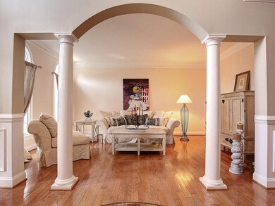 Living Room with detailed crown molding and arched