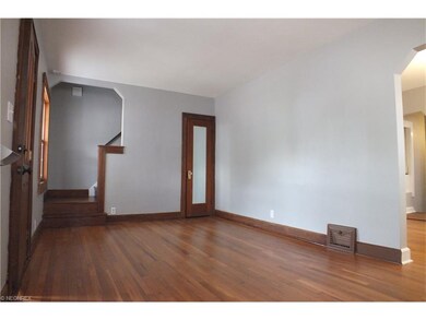 The living room  showing wood staircase at rear le