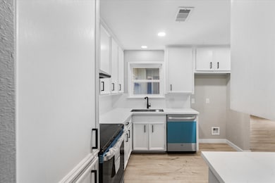 Bright, modern kitchen with white cabinetry, stain