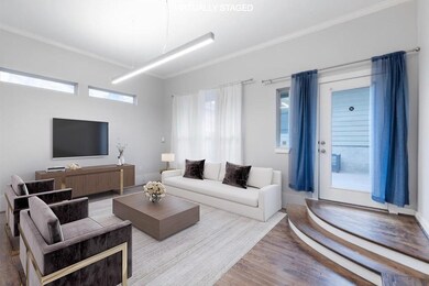 Living area with wood finished floors and crown m