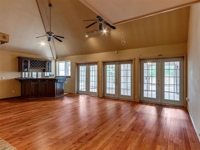 Unfurnished living room with french doors, light wood-style flooring, plenty of natural light, ceiling fan, and a textured ceiling