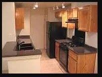 Kitchen with dark countertops, brown cabinets, an