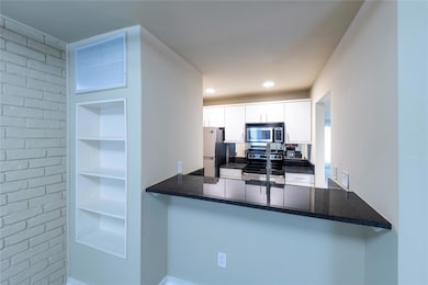 Kitchen with a peninsula, dark stone counters, whi