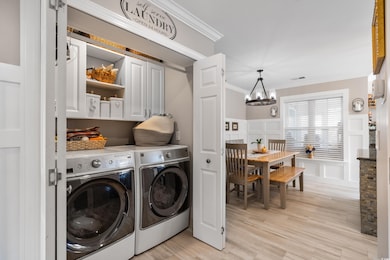 Washroom featuring an inviting chandelier, cabinet