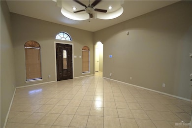 Entryway featuring a ceiling fan, arched walkways, and light tile patterned floors