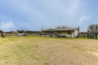 View of front of house with a rural view, fence, a