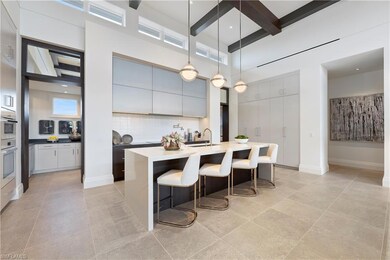 Kitchen featuring decorative backsplash, a breakfast bar, beam ceiling, a towering ceiling, and hanging light fixtures