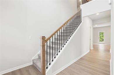 Stairs with wood finished floors, baseboards, and recessed lighting