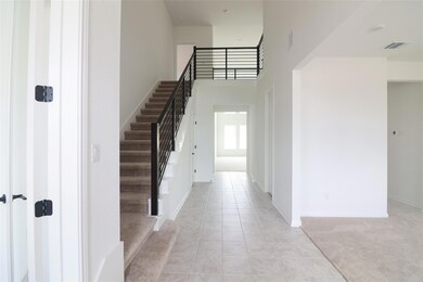 Foyer entrance with stairs, a high ceiling, light