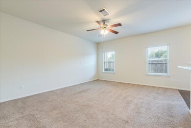 Spare room with a ceiling fan, carpet, and basebo