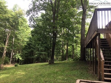A nearly level back yard surrounded by mature tree