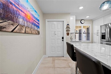 Kitchen with white cabinetry, light tile patterned