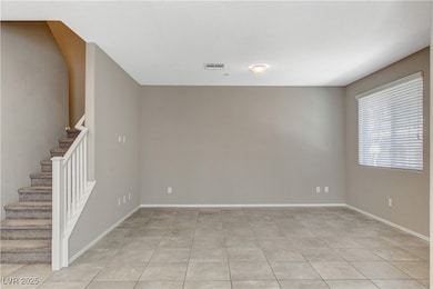 Empty room with stairs, baseboards, and light tile