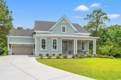 View of front of property with a porch, board and batten siding, a front yard, concrete driveway, and an attached garage