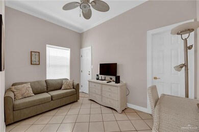 Tiled living room with ceiling fan and ornamental molding