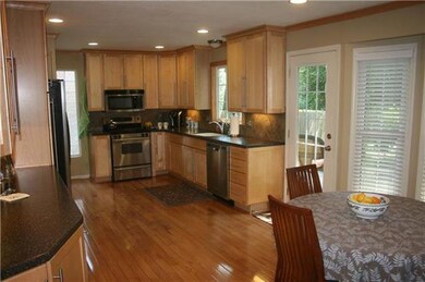 Hardwood floors cover the family room, kitchen, li