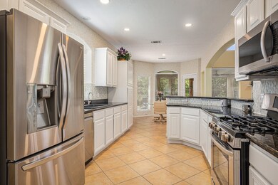 Well-appointed kitchen with white cabinetry, tile