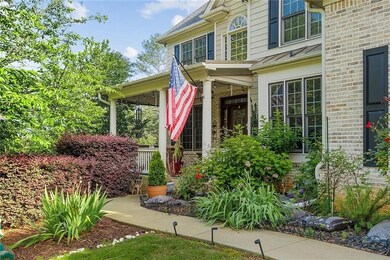 Doorway to property featuring covered porch and brick siding