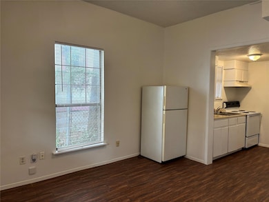 Kitchen with white appliances, baseboards, dark w