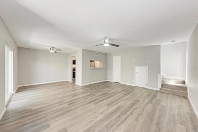 Unfurnished living room featuring ceiling fan, st