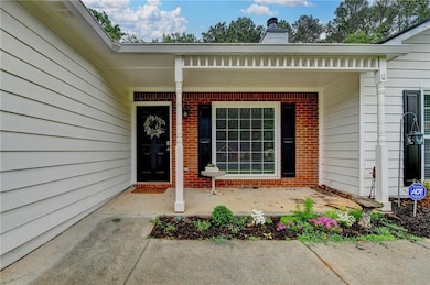 Property entrance featuring brick siding, covered 