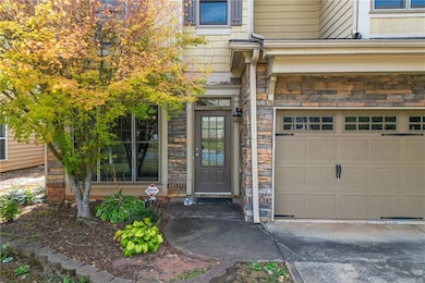 Property entrance featuring an attached garage and stone siding