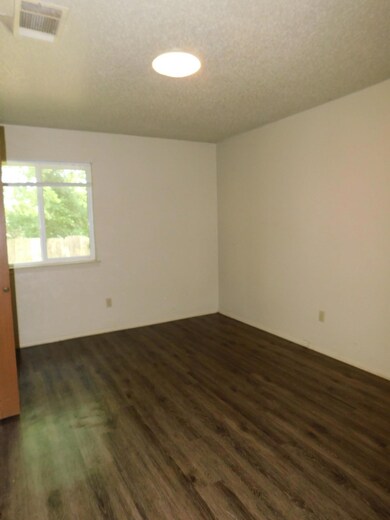 Spare room featuring dark wood finished floors, v