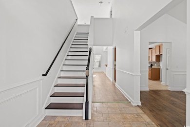Staircase with a high ceiling and stone finish flo