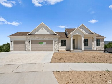 View of front facade featuring board and batten siding, an attached garage, stone siding, and concrete driveway