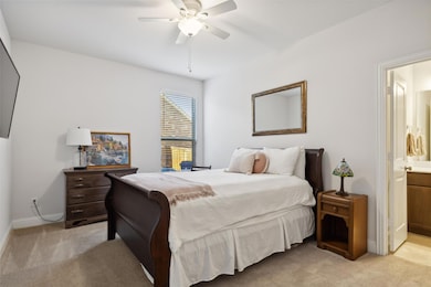 Bedroom featuring light colored carpet, ceiling fa