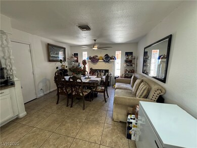 Dining area with a ceiling fan, a textured ceiling
