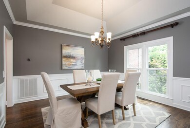 Beautiful formal dining room with tray ceiling and wainscoting