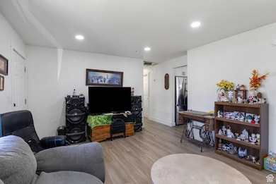 Living room with light wood-style floors and recessed lighting