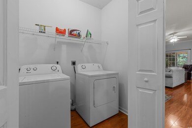 Washroom with separate washer and dryer, ceiling fan, and wood finished floors