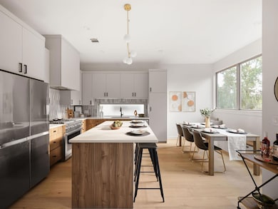 Kitchen with appliances with stainless steel finishes, light countertops, a breakfast bar, light wood finished floors, and decorative backsplash