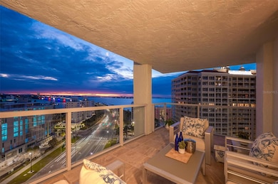 As night falls, the Ringling Bridge lights up in color and the city comes alive under Sarasota's evening glow.