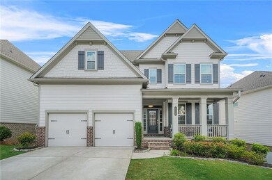 Craftsman-style house featuring a porch, a garage, driveway, and brick siding