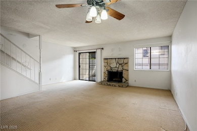 Unfurnished living room featuring a stone fireplac