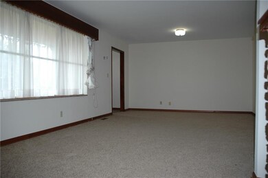 Big window in the large living room and new carpet.