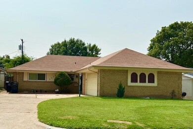 Ranch-style house with a garage and a front lawn