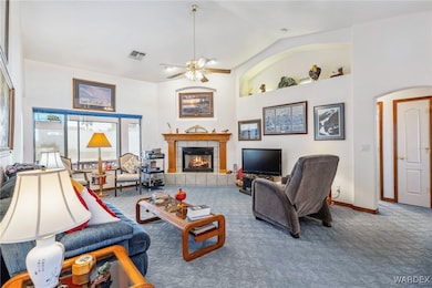 Carpeted living room with a fireplace, vaulted cei