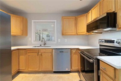 Kitchen with appliances with stainless steel finishes, light brown cabinets, light countertops, and light tile patterned floors