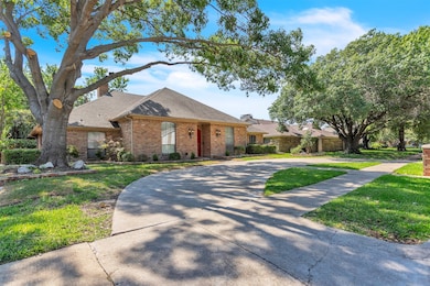 Ranch-style home featuring a shingled roof, brick siding, a front lawn, and a chimney